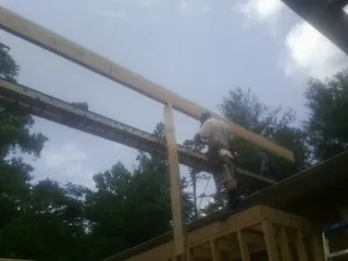 Carpenter setting a ridge beam over a new addition frame — Ice Dam Removal by Roofing Brothers in Aspers