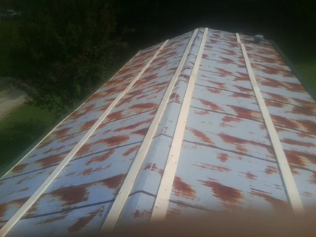 Rusted metal roof panels with new wood purlins before replacement — Storm Damage Roof Repair in Aspers by Roofing Brothers