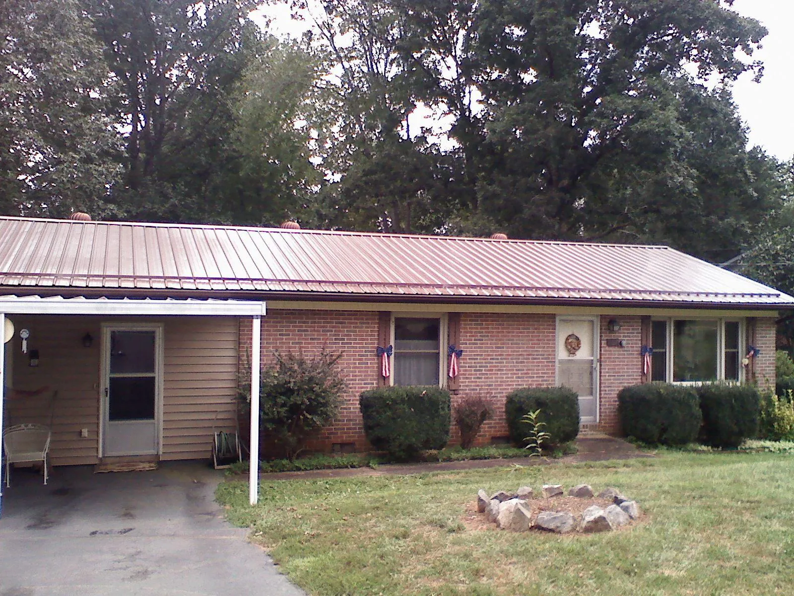 Bronze metal roof and carport on a brick ranch home — Roof Repair work by our crew in Aspers